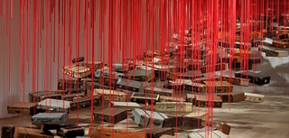 Chiharu Shiota, Japan/Germany b.1972 / Installation view of Accumulation: Searching for the Destination 2014/2022 in ‘Chiharu Shiota: The Soul Trembles’, Gallery of Modern Art, Brisbane / Suitcase, motor and red rope / © Chiharu Shiota / Courtesy: Galerie Templon, Paris/Brussels / Photograph: M Campbell © QAGOMA
